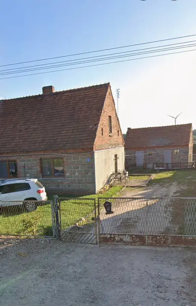 Budynek gospodarczy przed ociepleniem — mur z pustaków, widoczne ubytki tynku