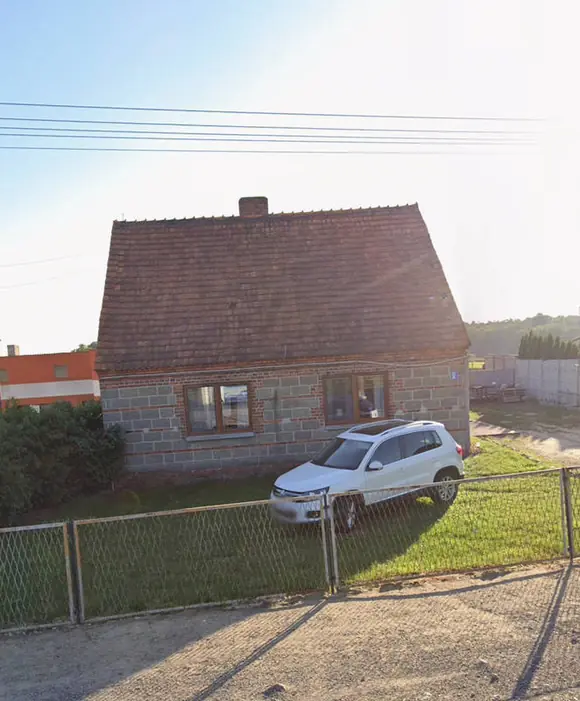 Dom jednorodzinny przed ociepleniem — odsłonięty mur z pustaków, stara stolarka okienna